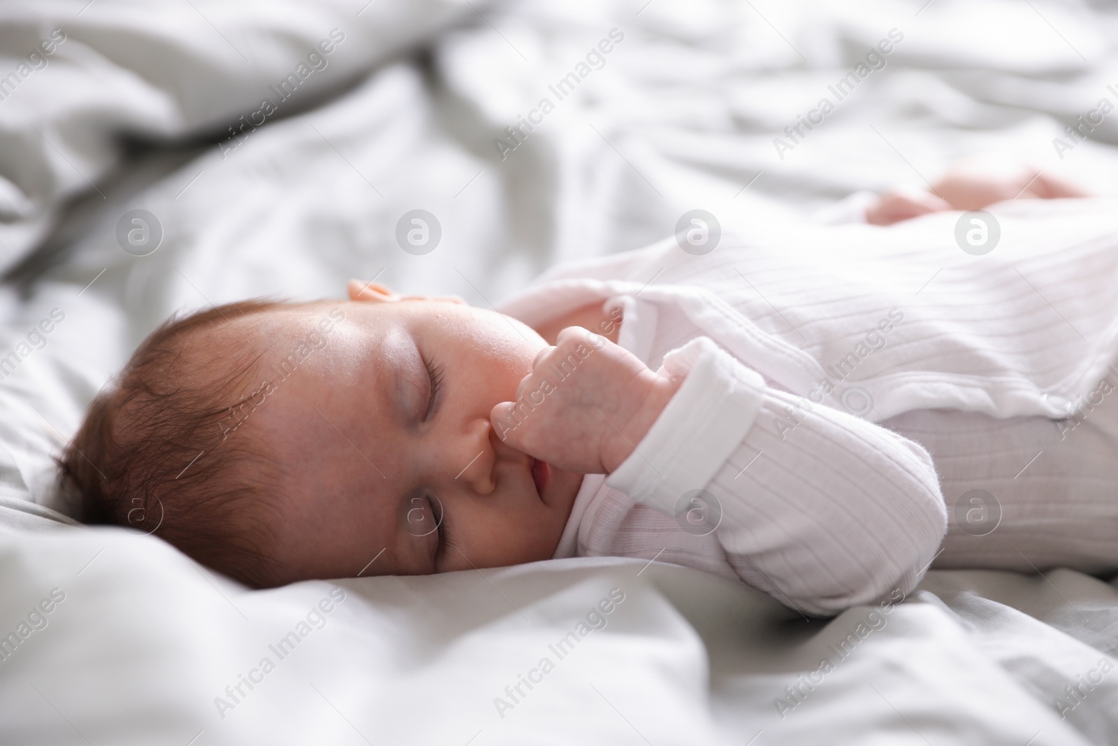 Cute newborn baby sleeping on bed, closeup Photo of Cute newborn baby sleeping on bed, closeup