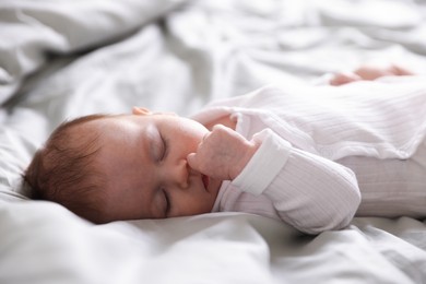 Photo of Cute newborn baby sleeping on bed, closeup