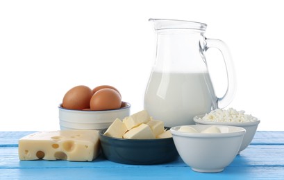 Photo of Different dairy products and eggs on blue wooden table against white background