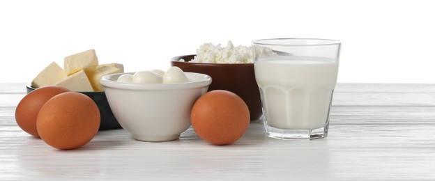 Photo of Different dairy products and eggs on wooden table against white background