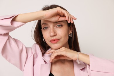 Photo of Portrait of beautiful woman in stylish outfit on white background