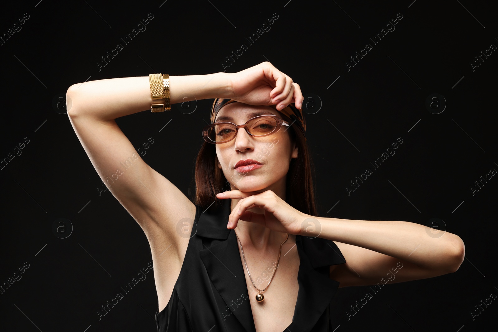 Photo of Portrait of beautiful woman in stylish outfit on black background