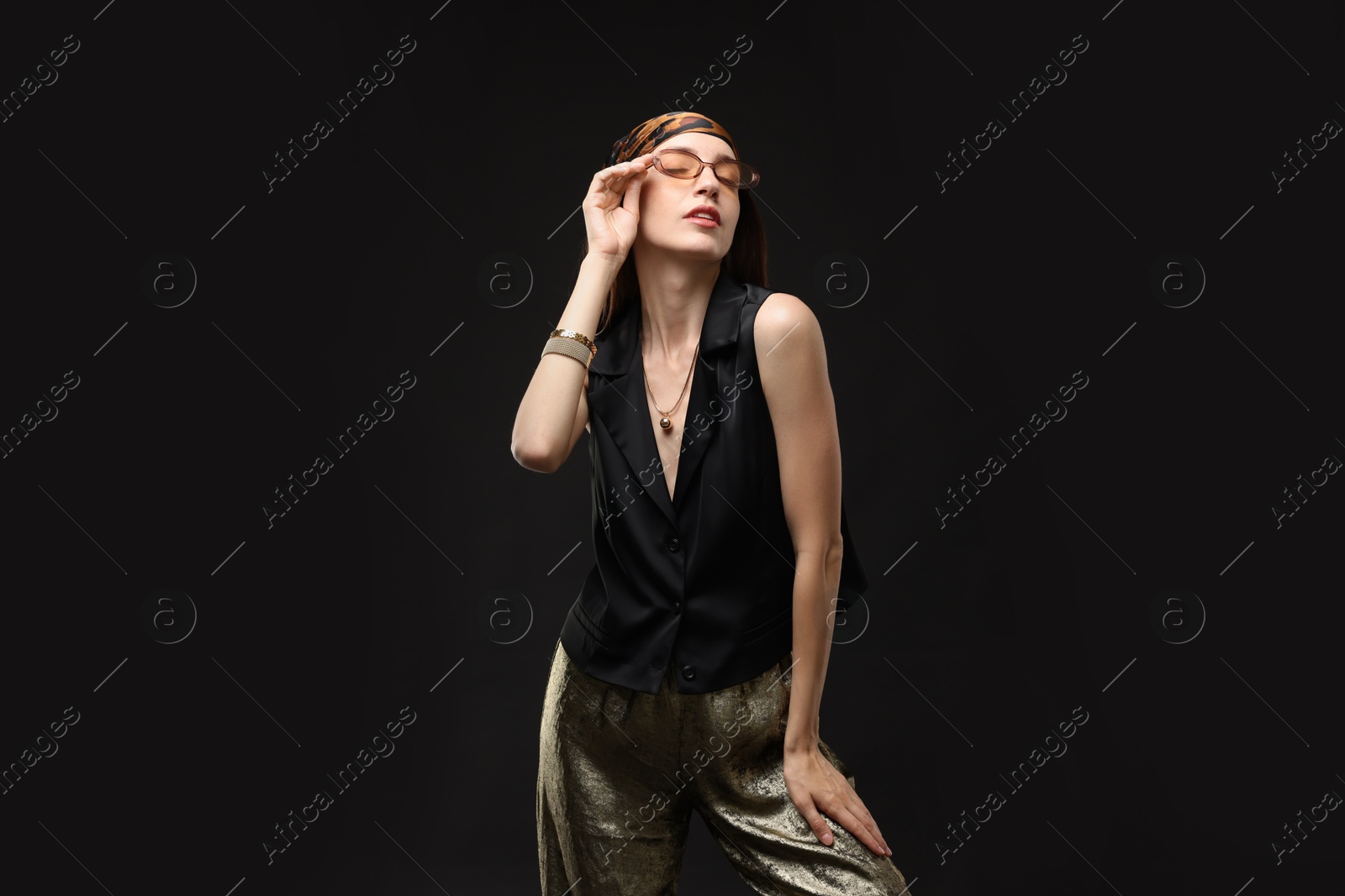 Portrait of beautiful woman in stylish outfit on black background Photo of Portrait of beautiful woman in stylish outfit on black background