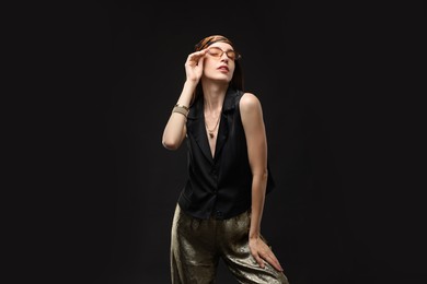 Photo of Portrait of beautiful woman in stylish outfit on black background