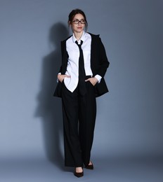 Photo of Full-length portrait of beautiful woman in stylish outfit on light grey background