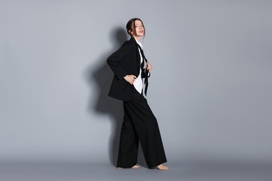 Photo of Full-length portrait of beautiful woman in stylish outfit on light grey background