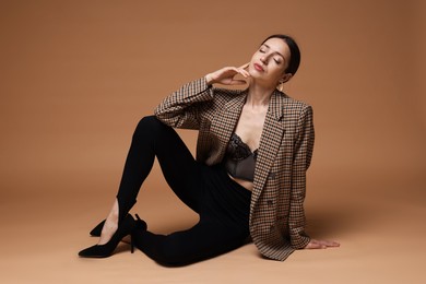Photo of Full-length portrait of beautiful woman in stylish outfit on beige background