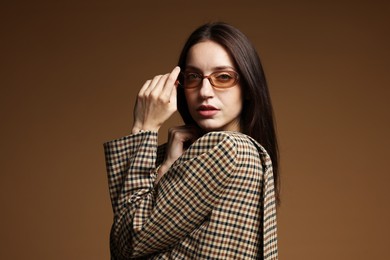 Photo of Portrait of beautiful woman in stylish outfit on brown background