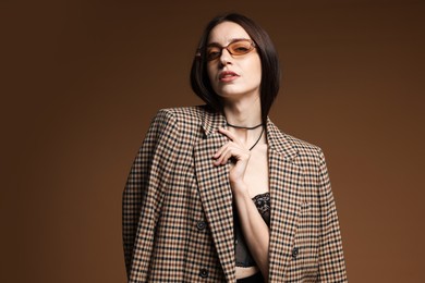 Photo of Portrait of beautiful woman in stylish outfit on brown background