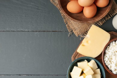 Photo of Different dairy products and eggs on grey wooden table, flat lay. Space for text