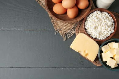 Photo of Different dairy products and eggs on grey wooden table, flat lay. Space for text