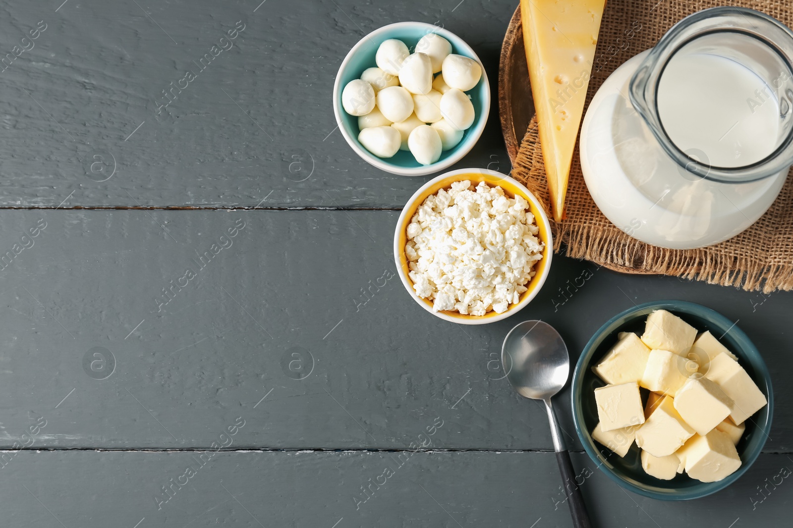 Photo of Different dairy products on grey wooden table, flat lay. Space for text