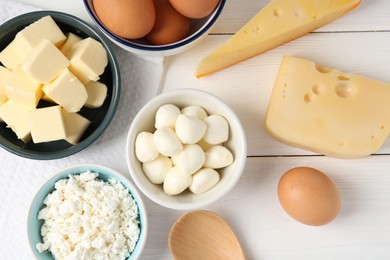 Photo of Different dairy products and eggs on white wooden table, flat lay