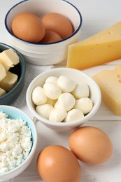 Photo of Different dairy products and eggs on white wooden table, closeup