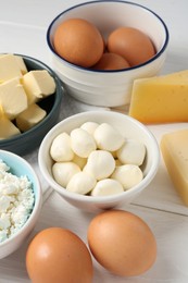 Photo of Different dairy products and eggs on white wooden table, closeup