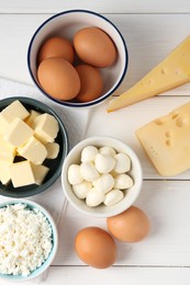 Photo of Different dairy products and eggs on white wooden table, flat lay