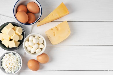 Photo of Different dairy products and eggs on white wooden table, flat lay. Space for text
