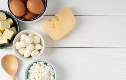 Photo of Different dairy products and eggs on white wooden table, flat lay. Space for text