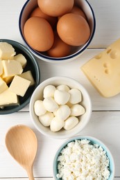 Photo of Different dairy products and eggs on white wooden table, flat lay