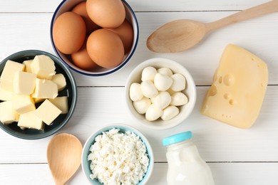 Photo of Different dairy products and eggs on white wooden table, flat lay