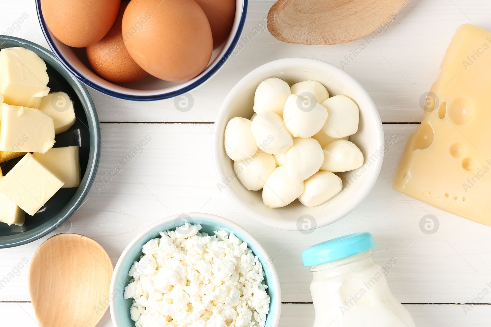 Photo of Different dairy products and eggs on white wooden table, flat lay