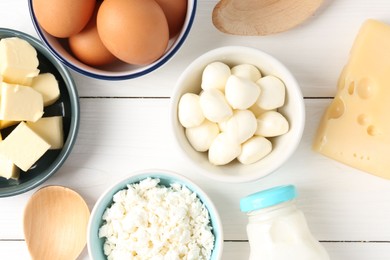 Photo of Different dairy products and eggs on white wooden table, flat lay