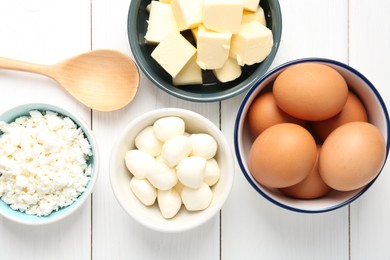 Photo of Different dairy products and eggs on white wooden table, flat lay