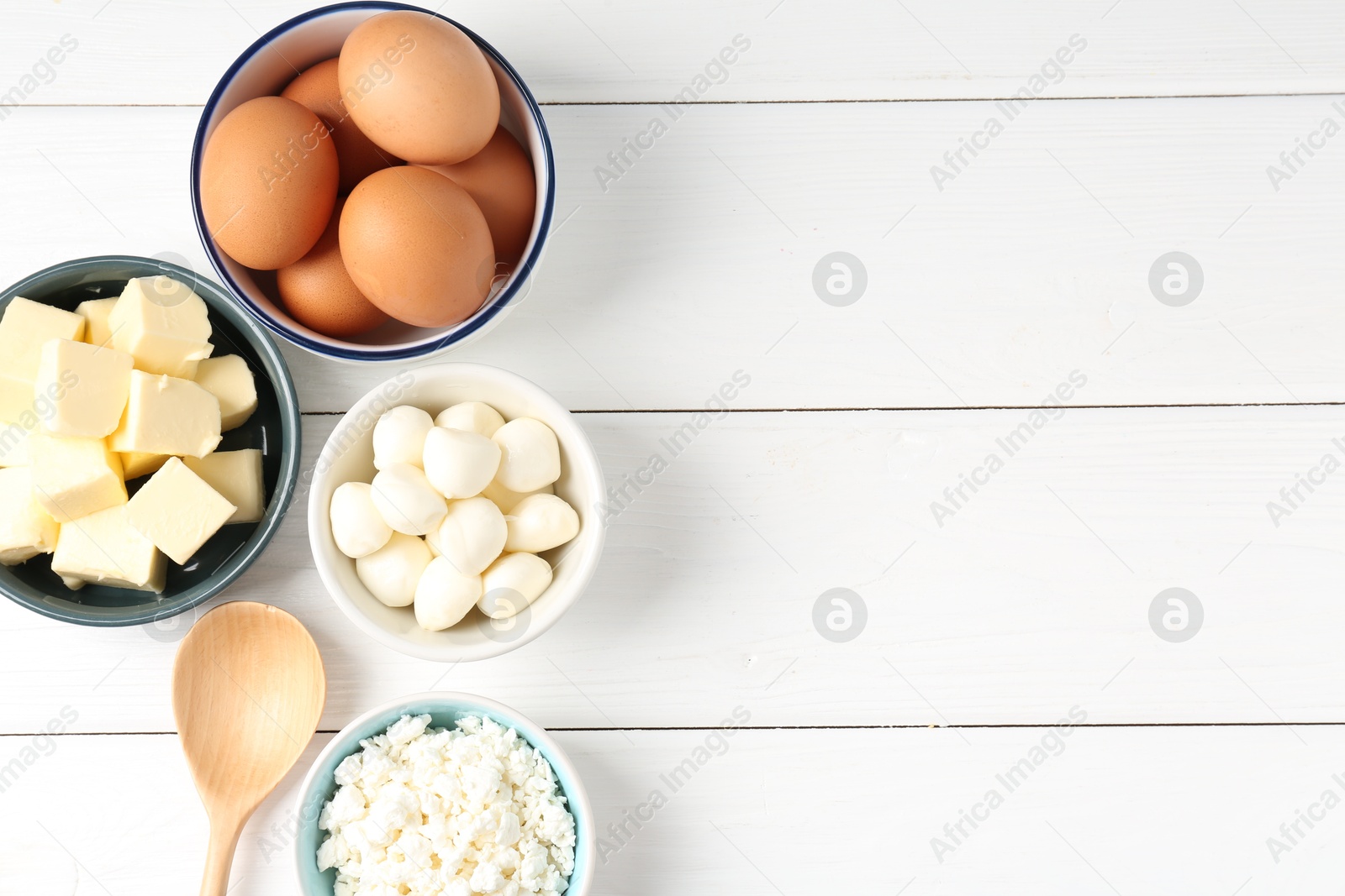 Photo of Different dairy products and eggs on white wooden table, flat lay. Space for text