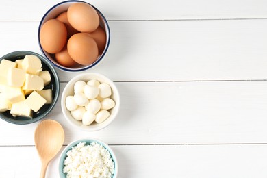 Photo of Different dairy products and eggs on white wooden table, flat lay. Space for text