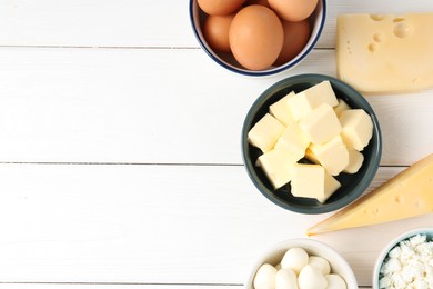 Photo of Different dairy products and eggs on white wooden table, flat lay. Space for text