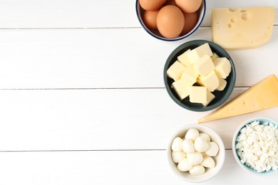 Photo of Different dairy products and eggs on white wooden table, flat lay. Space for text