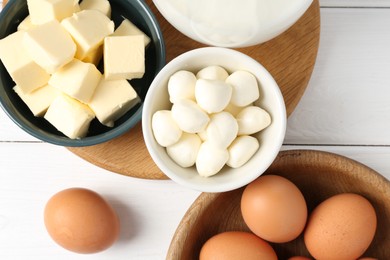 Photo of Different dairy products and eggs on white wooden table, flat lay