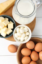 Photo of Different dairy products and eggs on white wooden table, flat lay
