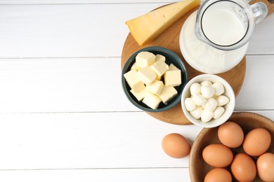 Photo of Different dairy products and eggs on white wooden table, flat lay. Space for text