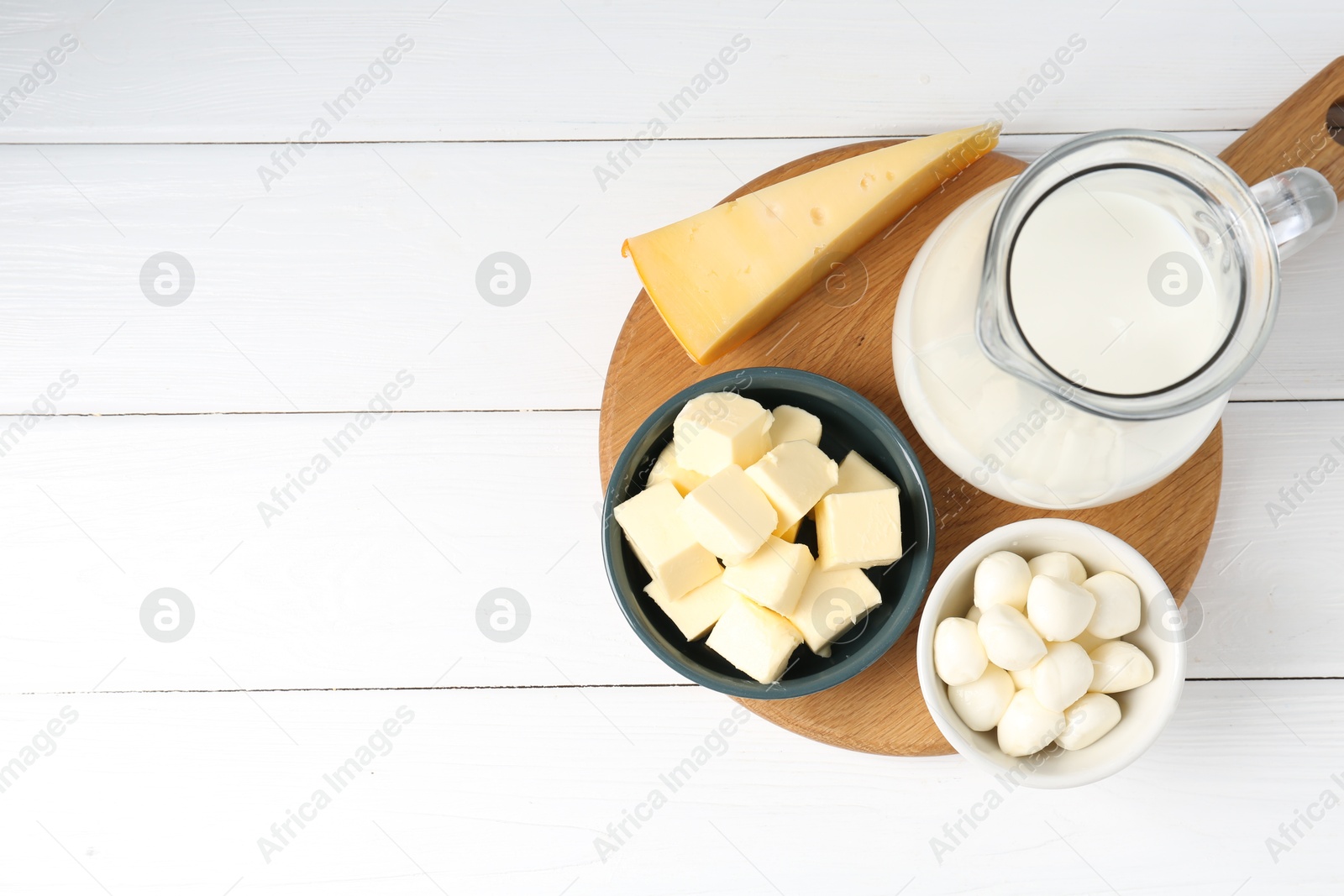 Photo of Different dairy products on white wooden table, top view. Space for text