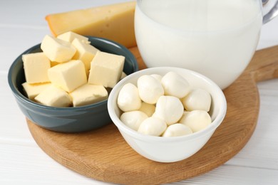 Photo of Different dairy products on white wooden table, closeup