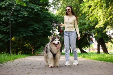 Photo of Happy woman with her cute Alaskan malamute dog in park, low angle view