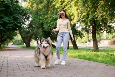 Photo of Happy woman with her cute Alaskan malamute dog in park