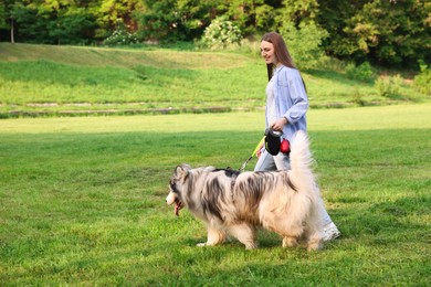 Photo of Happy woman walking with her cute Alaskan malamute dog on green grass outdoors. Space for text