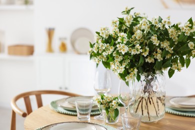Photo of Bouquet of beautiful jasmine flowers on dining table indoors. Space for text