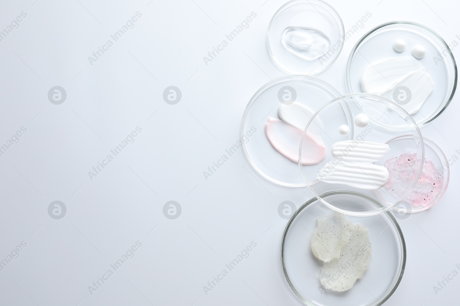Different cosmetic products in Petri dishes on white background, flat lay. Space for text Photo of Different cosmetic products in Petri dishes on white background, flat lay. Space for text