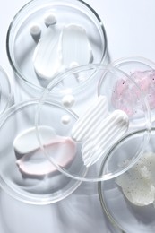 Photo of Different cosmetic products in Petri dishes on white background, closeup