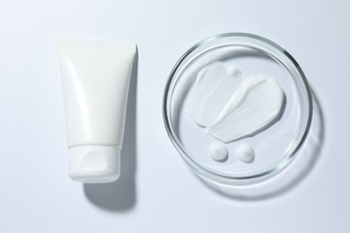 Photo of Cosmetic product in Petri dish and tube on white background, top view