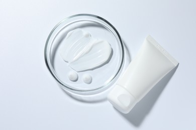 Photo of Cosmetic product in Petri dish and tube on white background, top view
