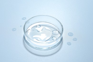 Photo of Cosmetic product in Petri dish on light blue background, closeup