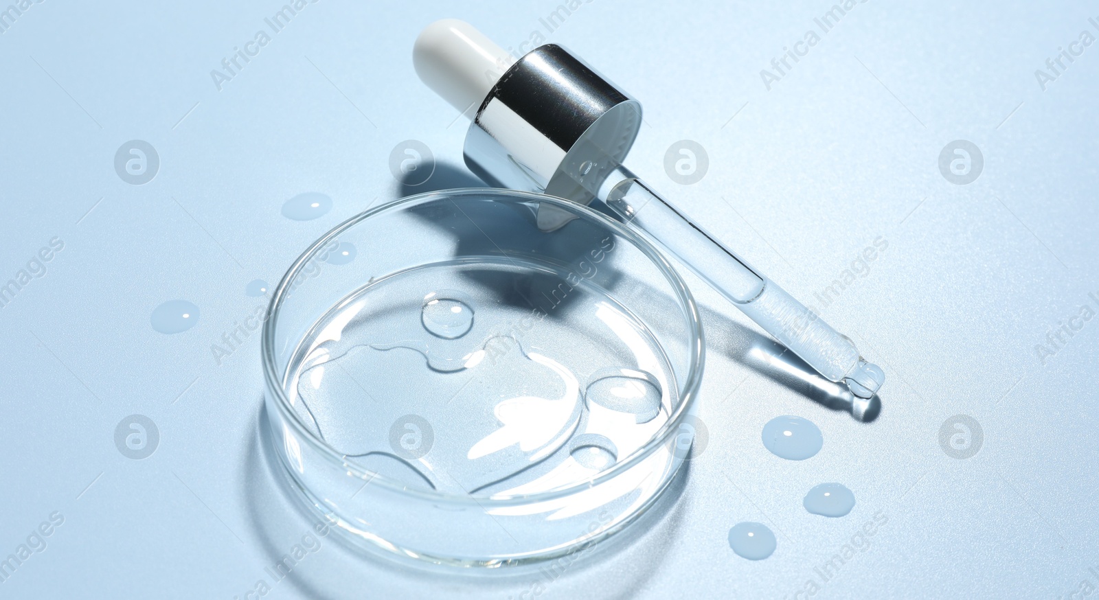Cosmetic product in Petri dish and dropper on light blue background, closeup Photo of Cosmetic product in Petri dish and dropper on light blue background, closeup