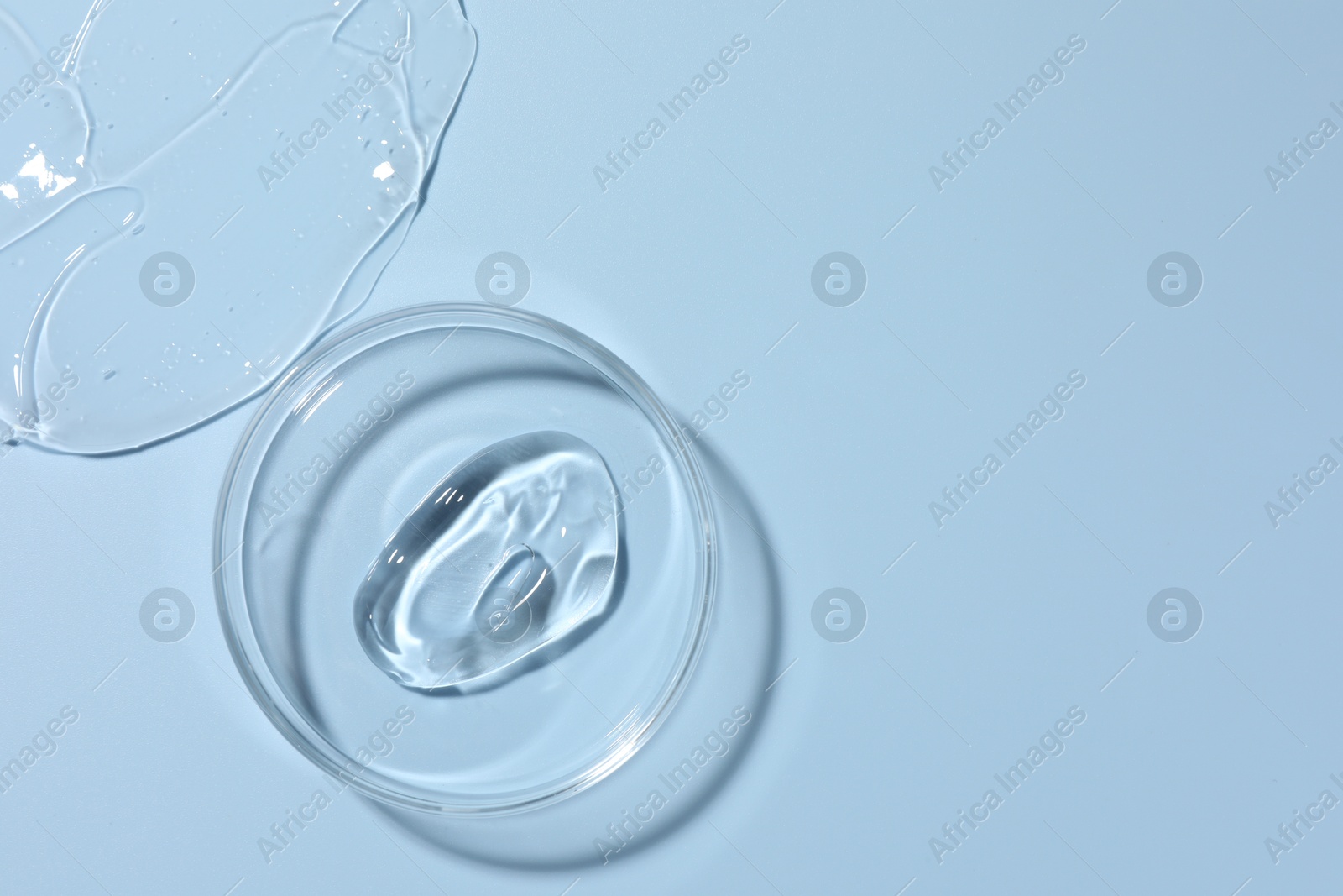 Cosmetic product in Petri dish on light blue background, top view. Space for text Photo of Cosmetic product in Petri dish on light blue background, top view. Space for text