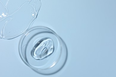 Photo of Cosmetic product in Petri dish on light blue background, top view. Space for text