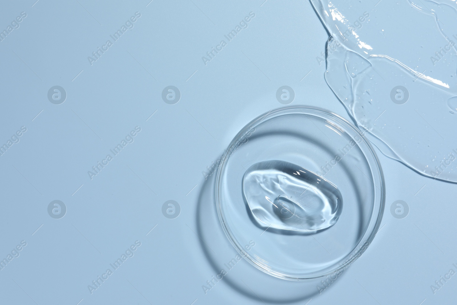Cosmetic product in Petri dish on light blue background, top view. Space for text Photo of Cosmetic product in Petri dish on light blue background, top view. Space for text