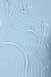 Photo of Sample of cosmetic product on light blue background, closeup
